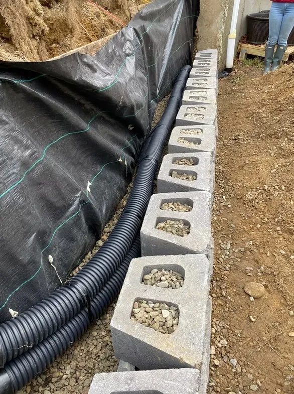 Retaining wall base and drainage installation in progress